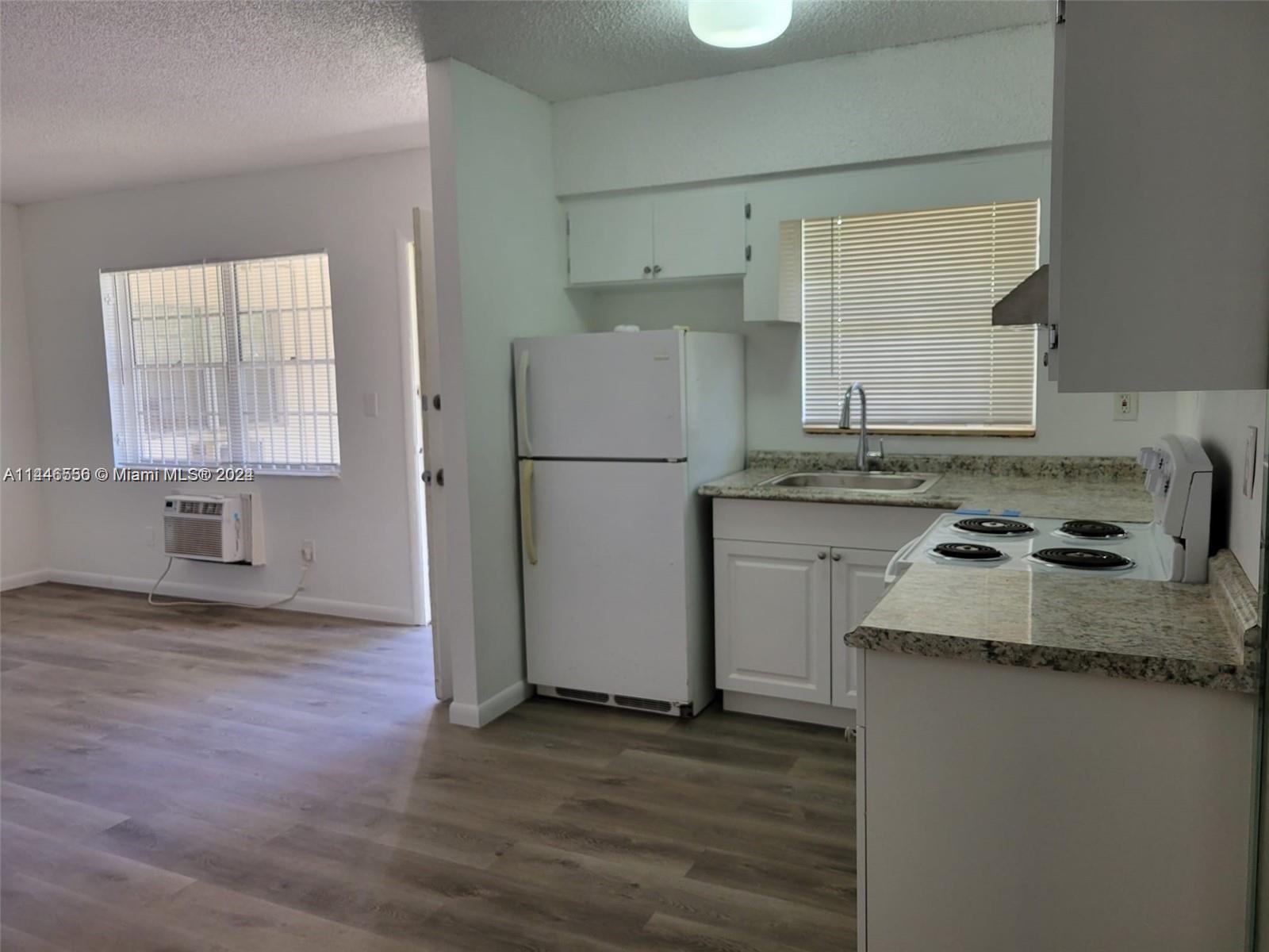 1755 Northeast 116th Road, Unit 9 North Miami, FL 33181 - Photo 6 of 27 a room with granite countertop cabinets and wooden floor