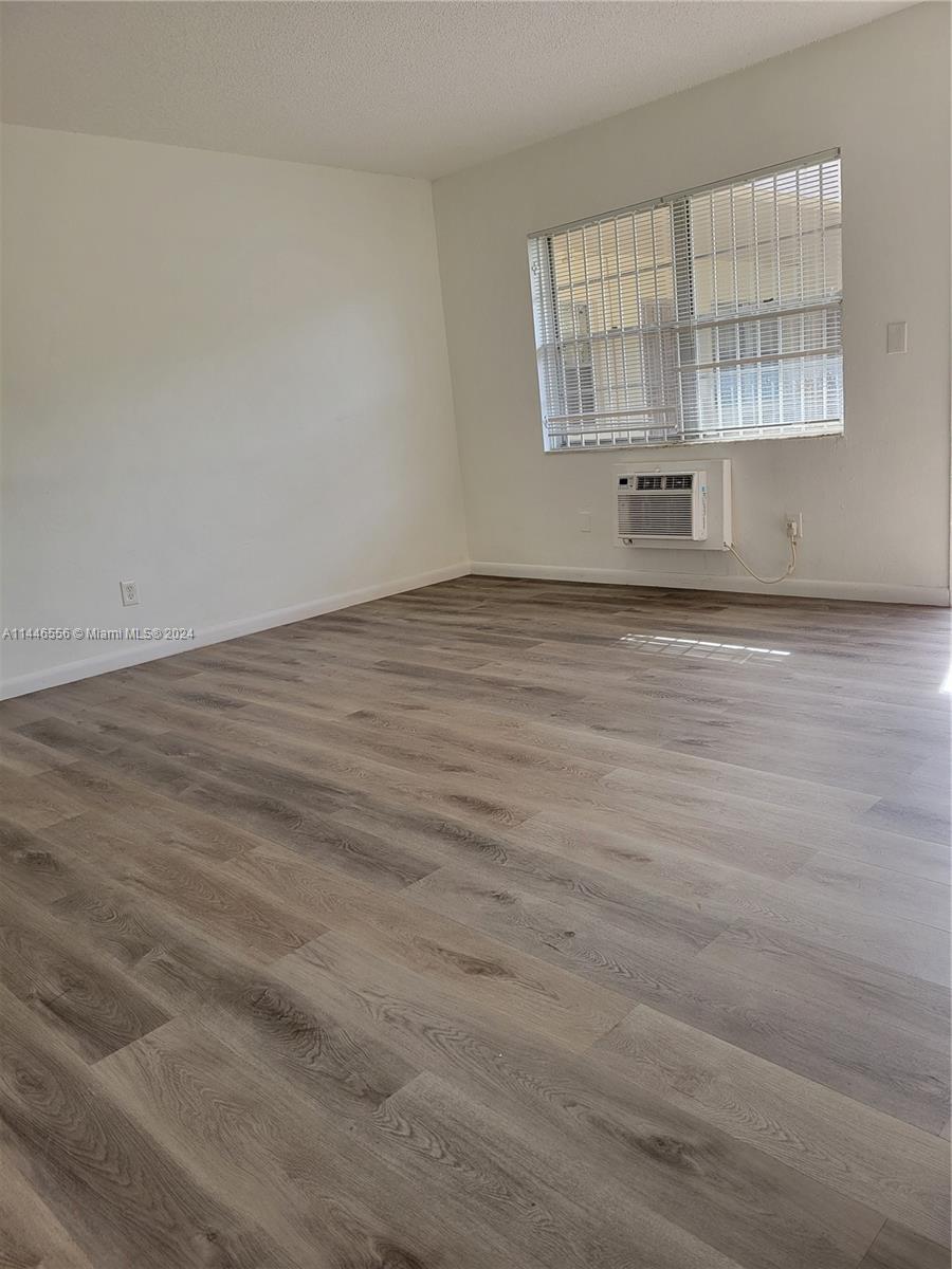 1755 Northeast 116th Road, Unit 9 North Miami, FL 33181 - Photo 9 of 27 an empty room with wooden floor and windows