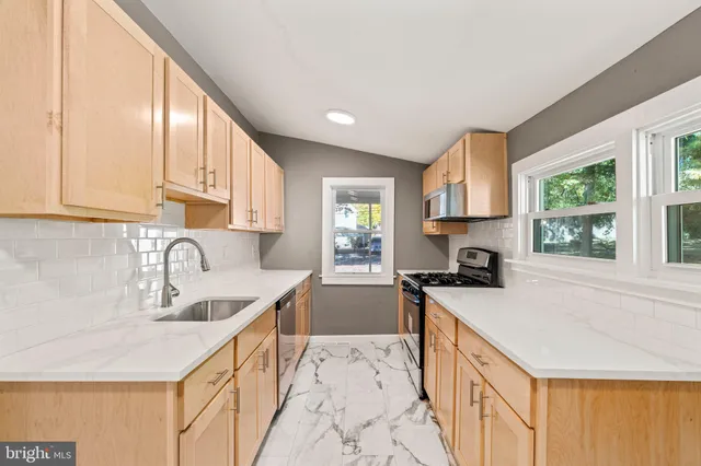a kitchen with a sink a stove and cabinets