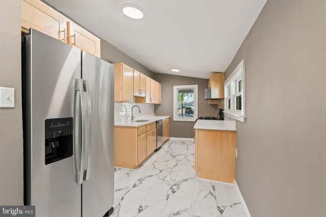 a kitchen with stainless steel appliances a refrigerator sink and cabinets