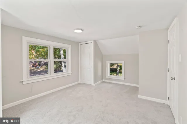 an empty room with windows and closet