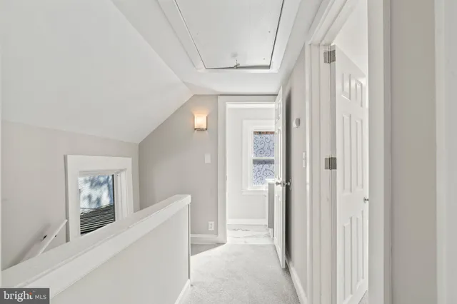 a view of a hallway with windows and closet