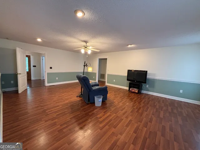 a view of a livingroom with wooden floor and a large window