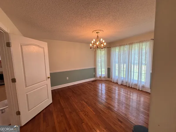 a kitchen with granite countertop a sink dishwasher stove and white cabinets