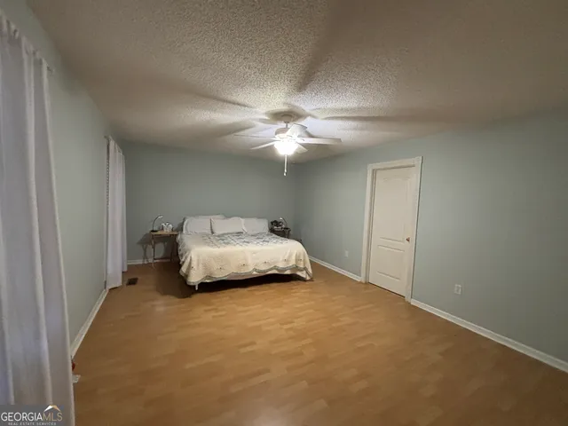 an empty room with windows and fan
