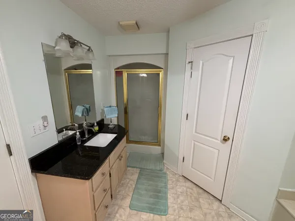 an empty room with wooden floor and fan