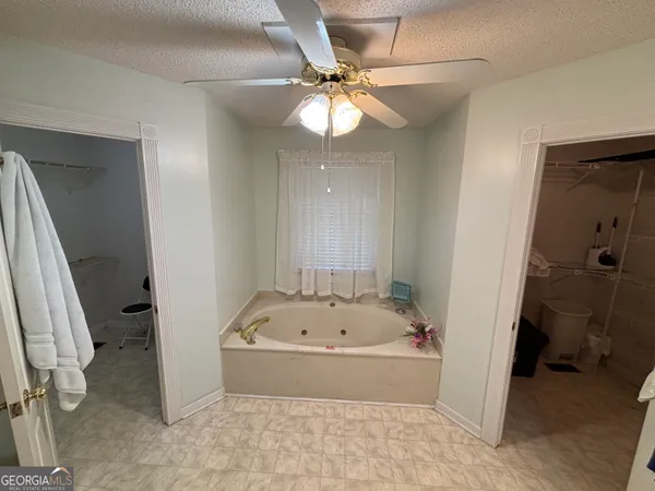 a view of an empty room with a chandelier fan