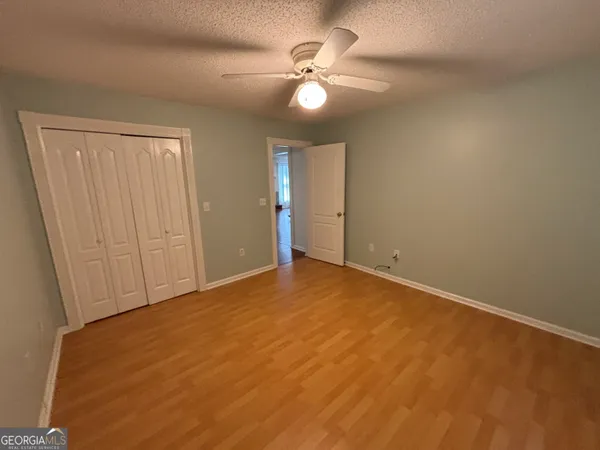 a view of a house with a yard and a large tree