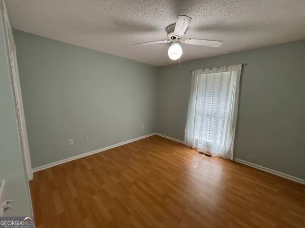 a view of a house with swimming pool and sitting area with a large tree