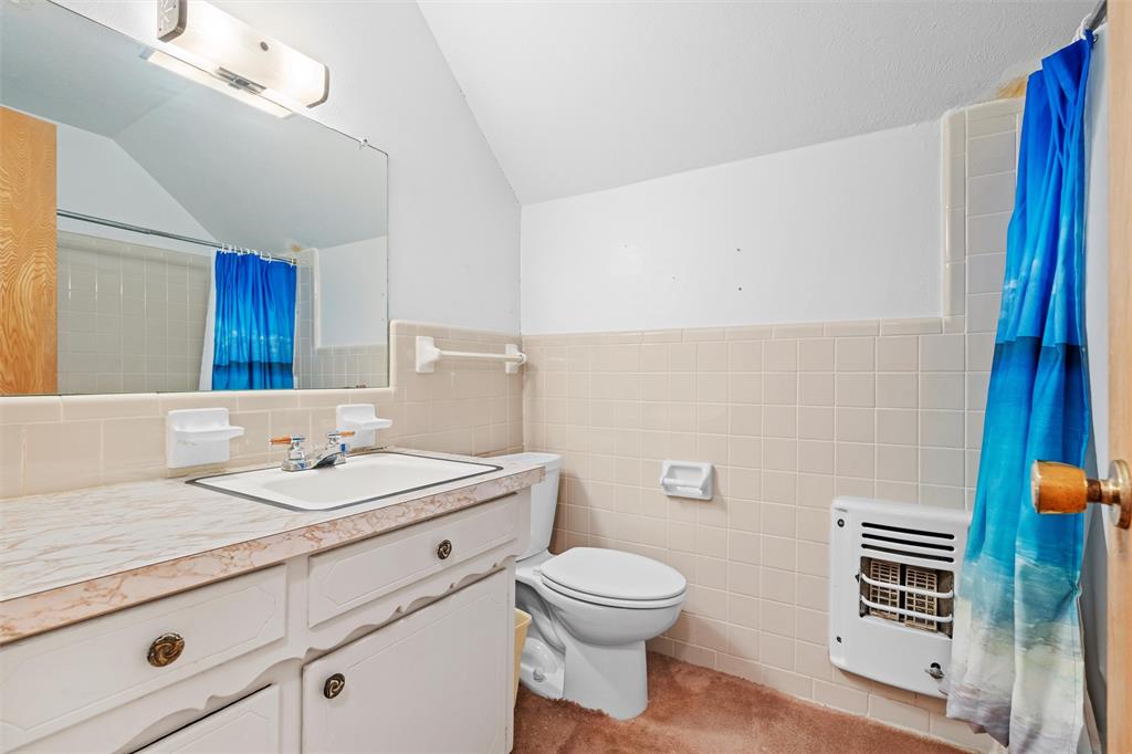 2828 Larkspur Lane Dallas, TX 75233 - Photo 26 of 31 a bathroom with a sink a toilet and mirror