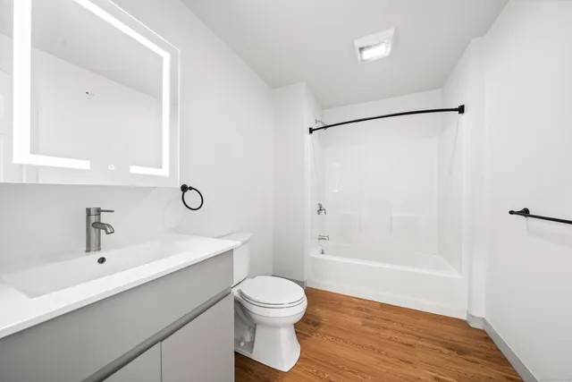 a bathroom with a sink a toilet and shower