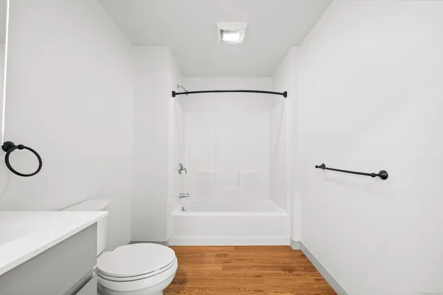 a bathroom with a shower a toilet and a sink