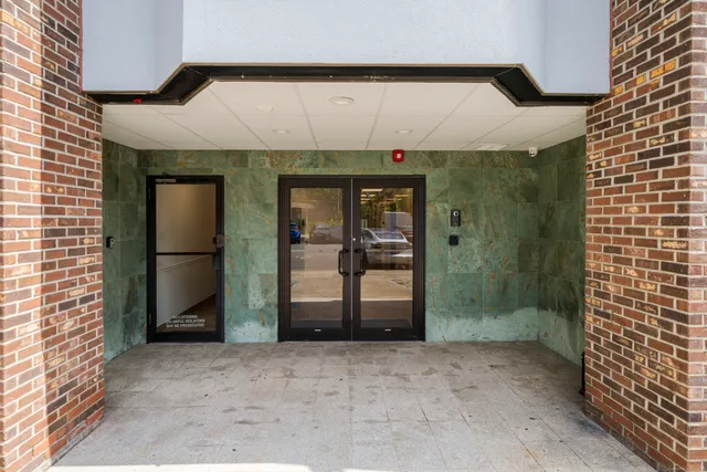 a view of a brick house with plants