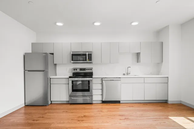a kitchen with stainless steel appliances a refrigerator stove microwave and sink
