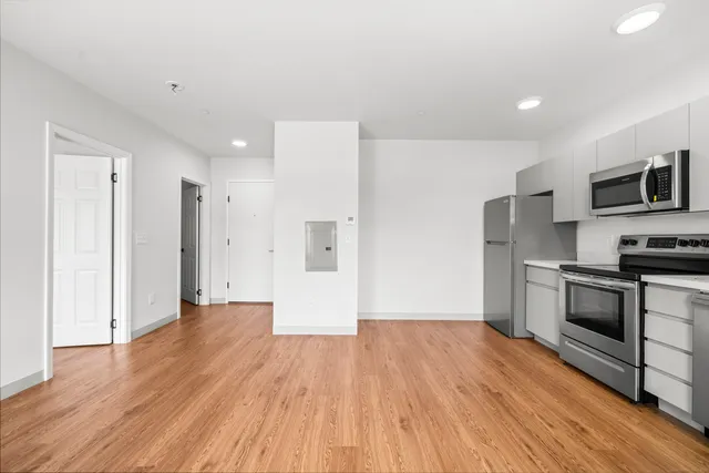 a view of a kitchen with wooden floor and electronic appliances