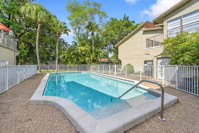a view of a backyard with a small deck and wooden fence