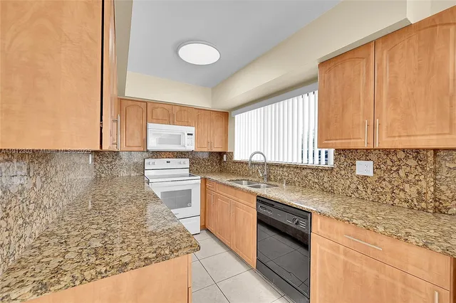 a kitchen with stainless steel appliances granite countertop a sink stove and cabinets