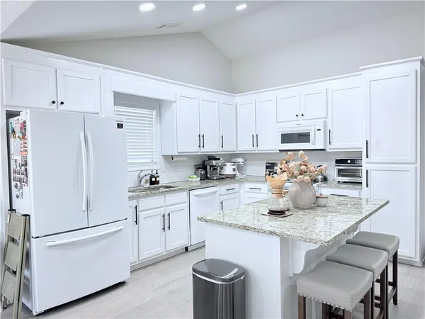 a kitchen with white cabinets and white appliances