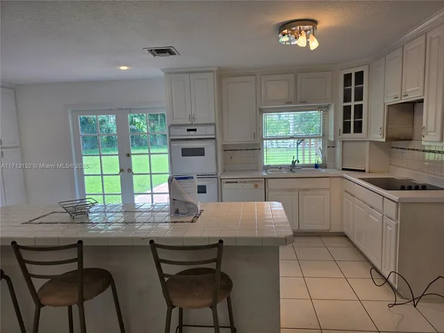 a kitchen with a table chairs sink and cabinets