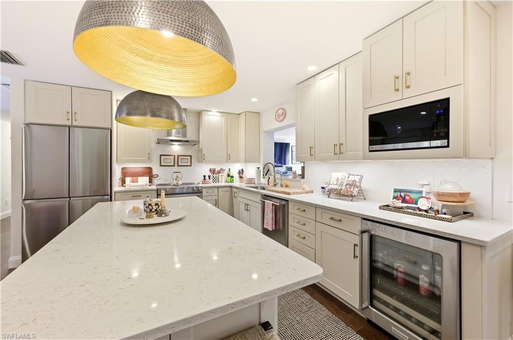 4630 11th Avenue Southwest Naples, FL 34116 - Photo 11 of 50 a kitchen with stainless steel appliances a stove a sink a microwave and cabinets