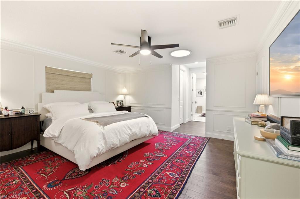 4630 11th Avenue Southwest Naples, FL 34116 - Photo 23 of 50 a bedroom with a large bed and a chandelier