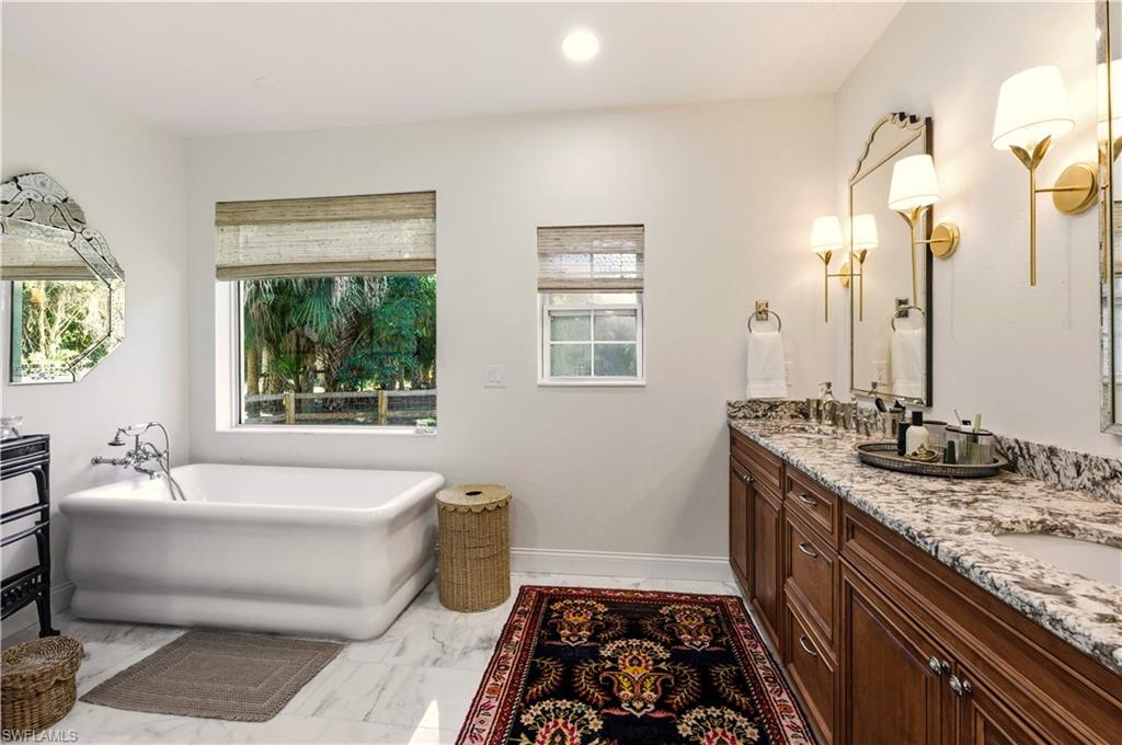 4630 11th Avenue Southwest Naples, FL 34116 - Photo 25 of 50 a spacious bathroom with a granite countertop tub and a sink