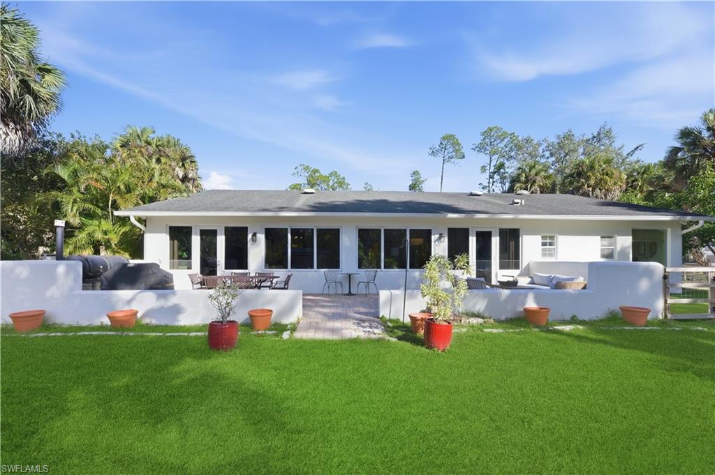 4630 11th Avenue Southwest Naples, FL 34116 - Photo 37 of 50 a front view of house with yard and outdoor seating