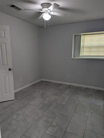 an empty room with a chandelier fan