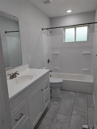 a bathroom with a bathtub sink vanity mirror and toilet