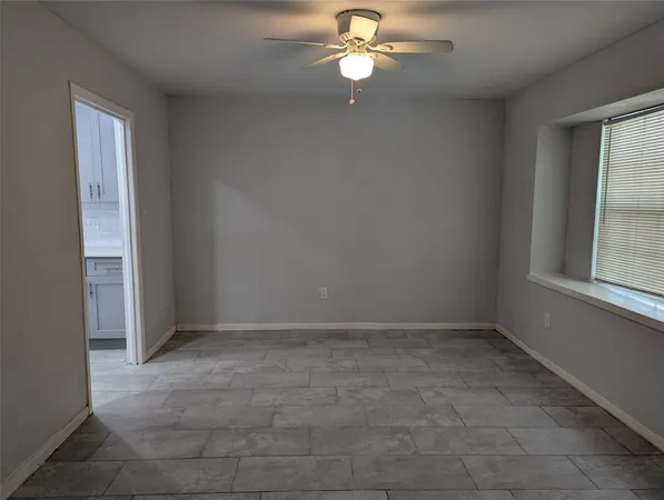 en empty room with windows and fan