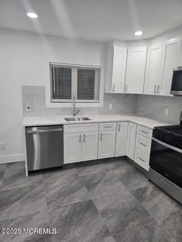 a large white kitchen with cabinets