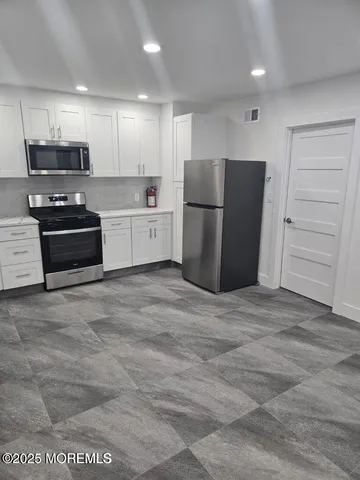 a kitchen with stainless steel appliances a refrigerator and a stove top oven