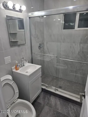 a bathroom with a sink a toilet and shower
