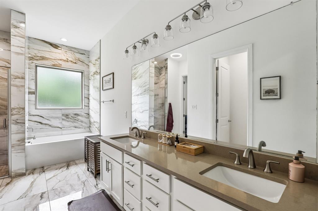 515 West Laureland Road Dallas, TX 75232 - Photo 24 of 32 a bathroom with double vanity sinks a large mirror and a bathtub