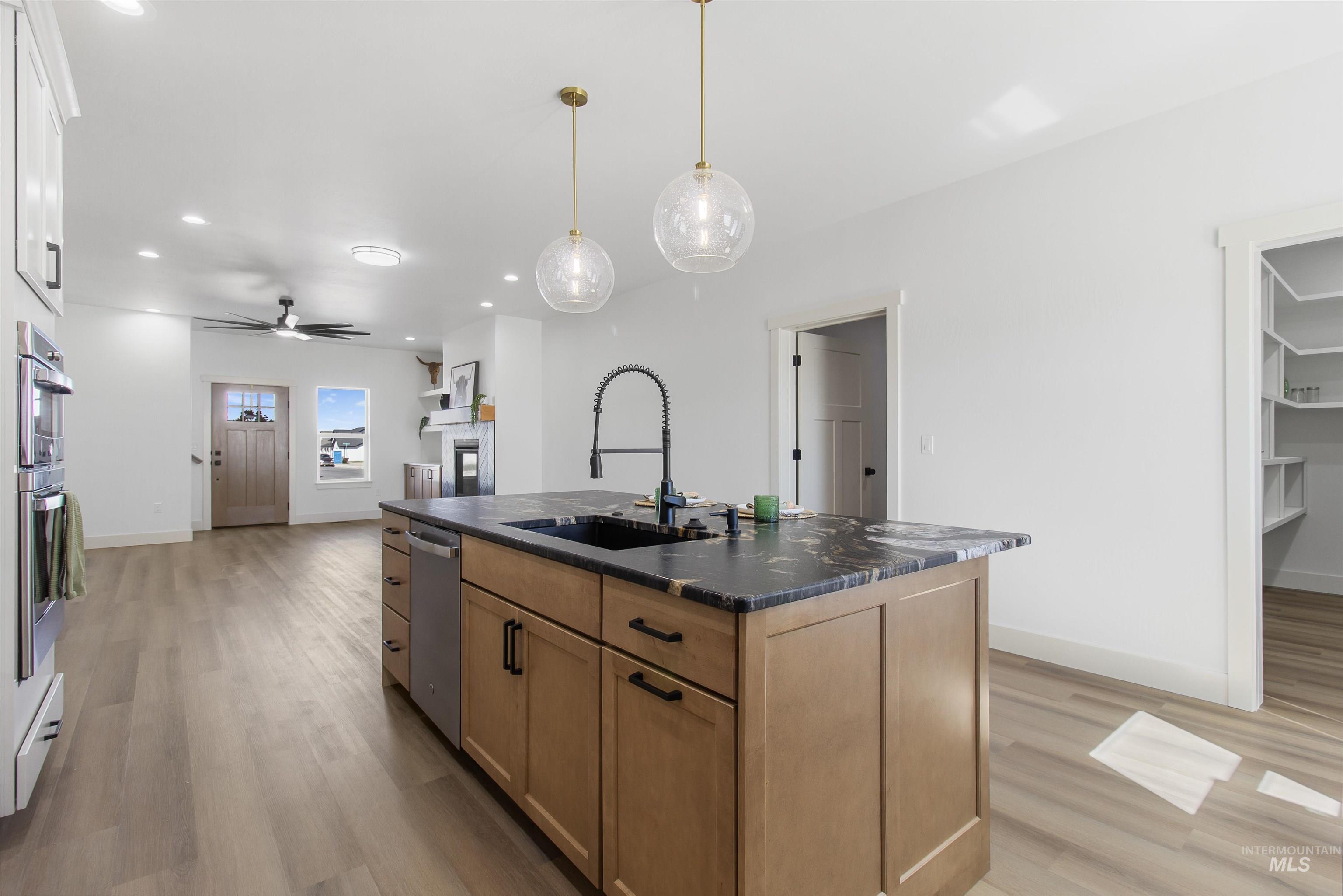 514 Full Moon Way Twin Falls, ID 83301 - Photo 11 of 49 Kitchen with an island with sink, light wood-style flooring, hanging light fixtures, and ceiling fan
