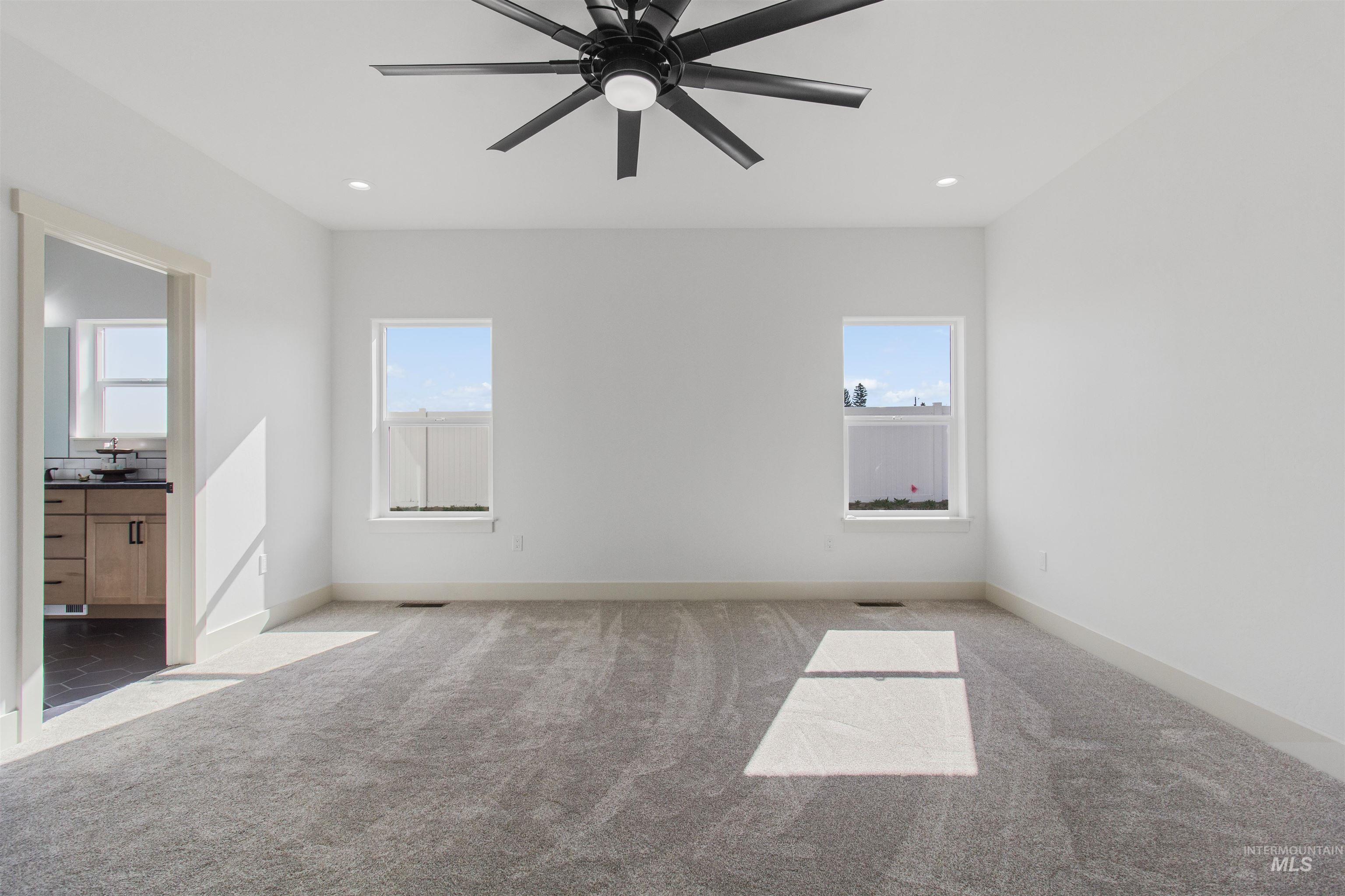 514 Full Moon Way Twin Falls, ID 83301 - Photo 19 of 49 Unfurnished bedroom with light carpet, ensuite bath, ceiling fan, multiple windows, and recessed lighting