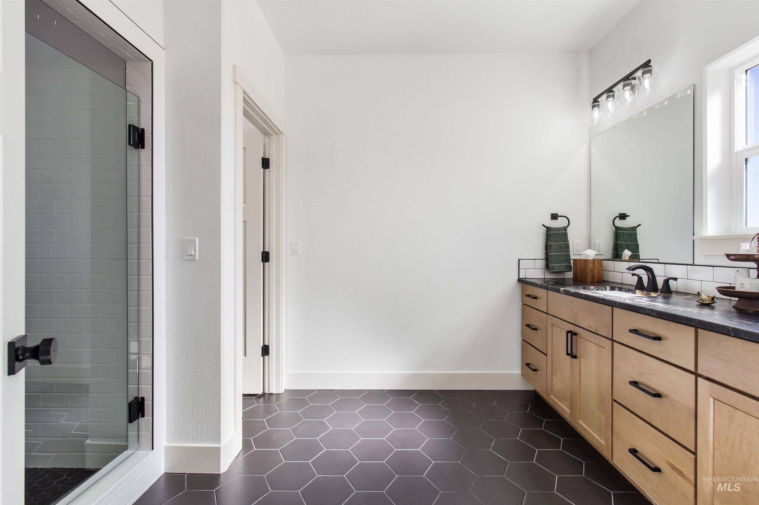 514 Full Moon Way Twin Falls, ID 83301 - Photo 21 of 49 Full bathroom featuring vanity, dark tile patterned flooring, and a shower stall