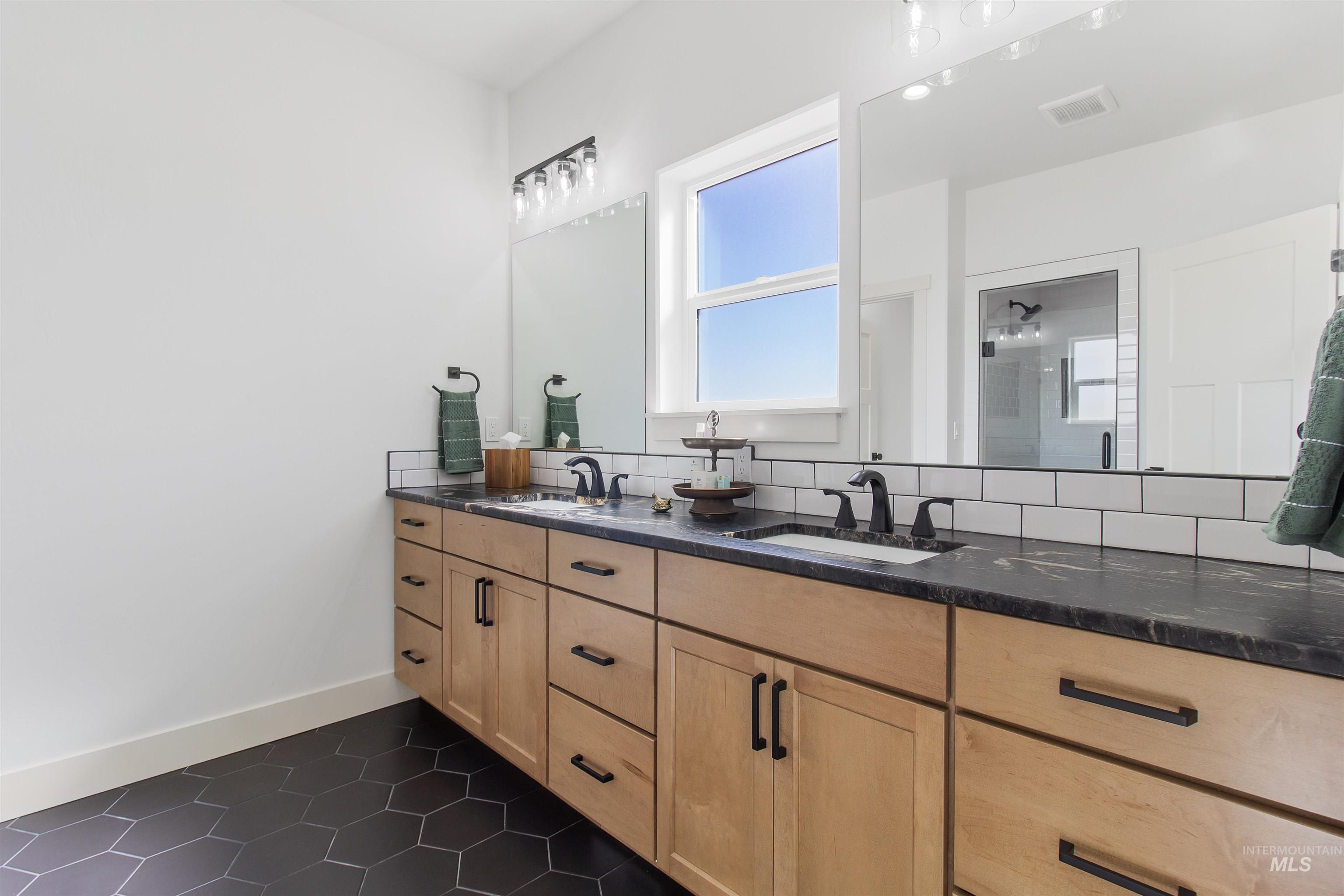 514 Full Moon Way Twin Falls, ID 83301 - Photo 23 of 49 Bathroom with double vanity, dark tile patterned floors, and a stall shower