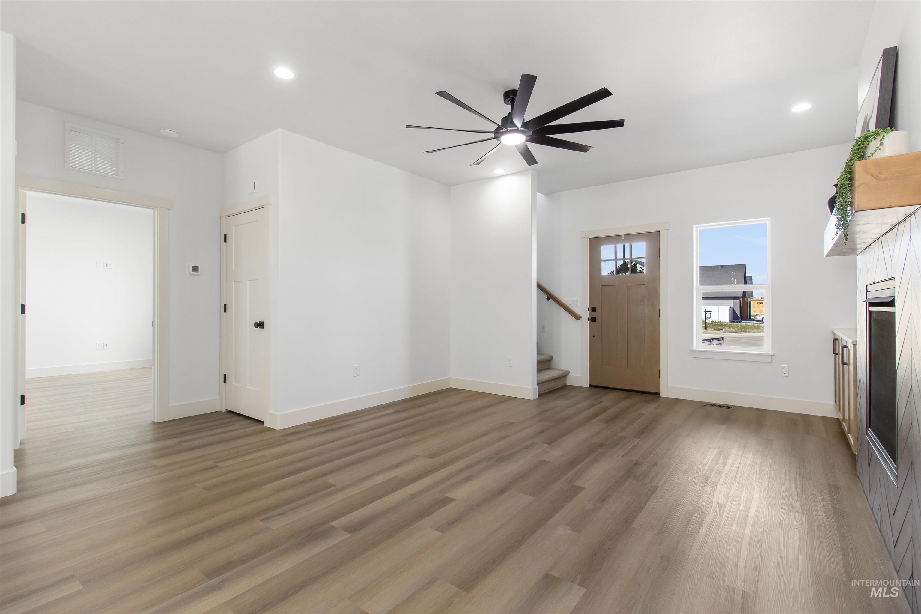 514 Full Moon Way Twin Falls, ID 83301 - Photo 3 of 49 Unfurnished living room featuring recessed lighting, ceiling fan, light wood-style flooring, and a fireplace