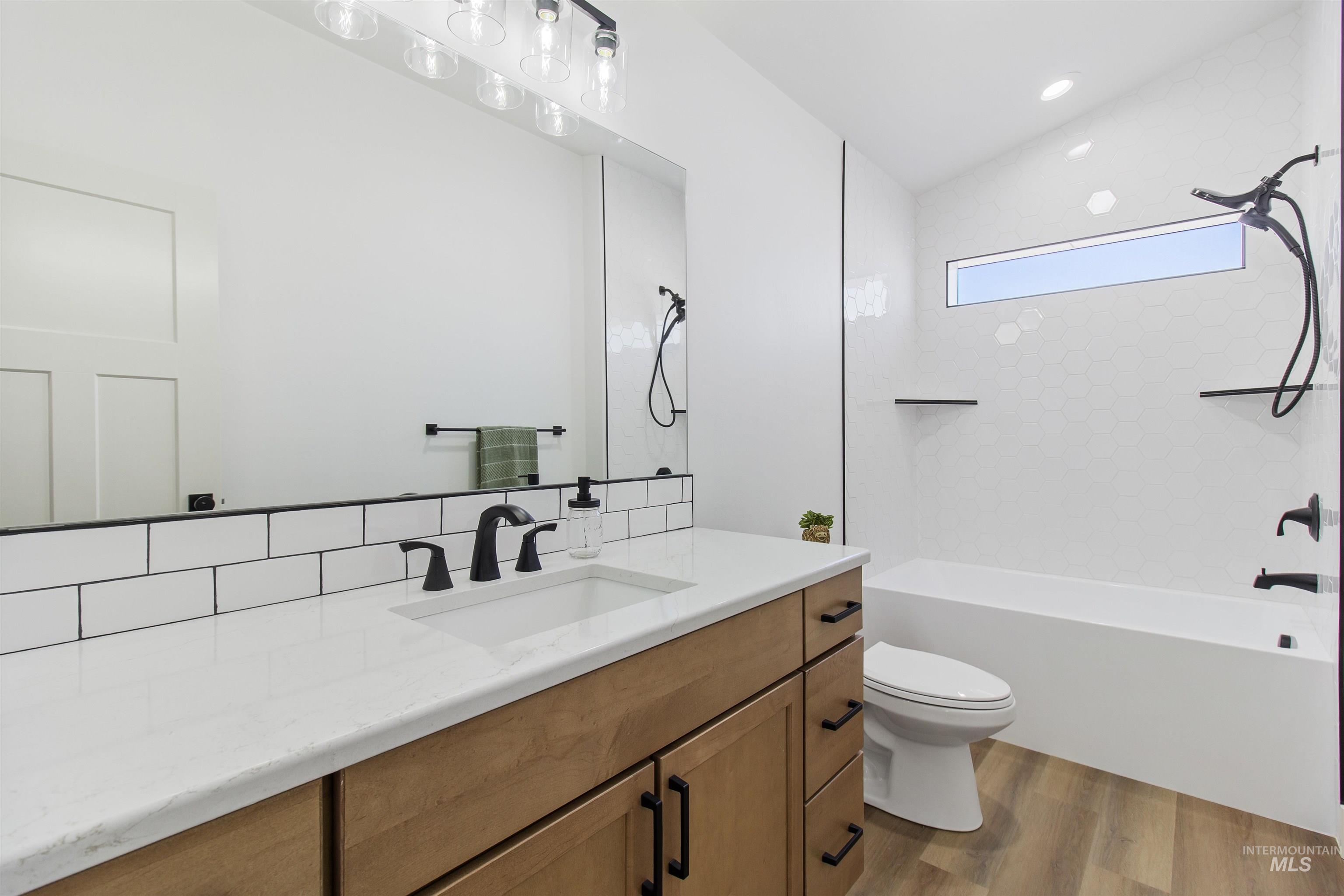 514 Full Moon Way Twin Falls, ID 83301 - Photo 34 of 49 Bathroom featuring vanity, tub / shower combination, light wood-type flooring, and recessed lighting