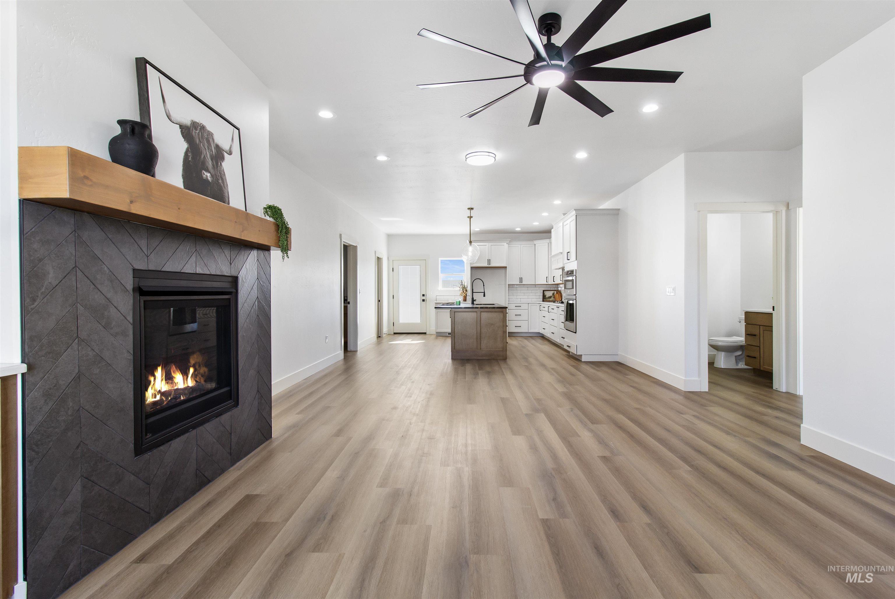 514 Full Moon Way Twin Falls, ID 83301 - Photo 6 of 49 Living area featuring a tile fireplace, recessed lighting, light wood-type flooring, and a ceiling fan