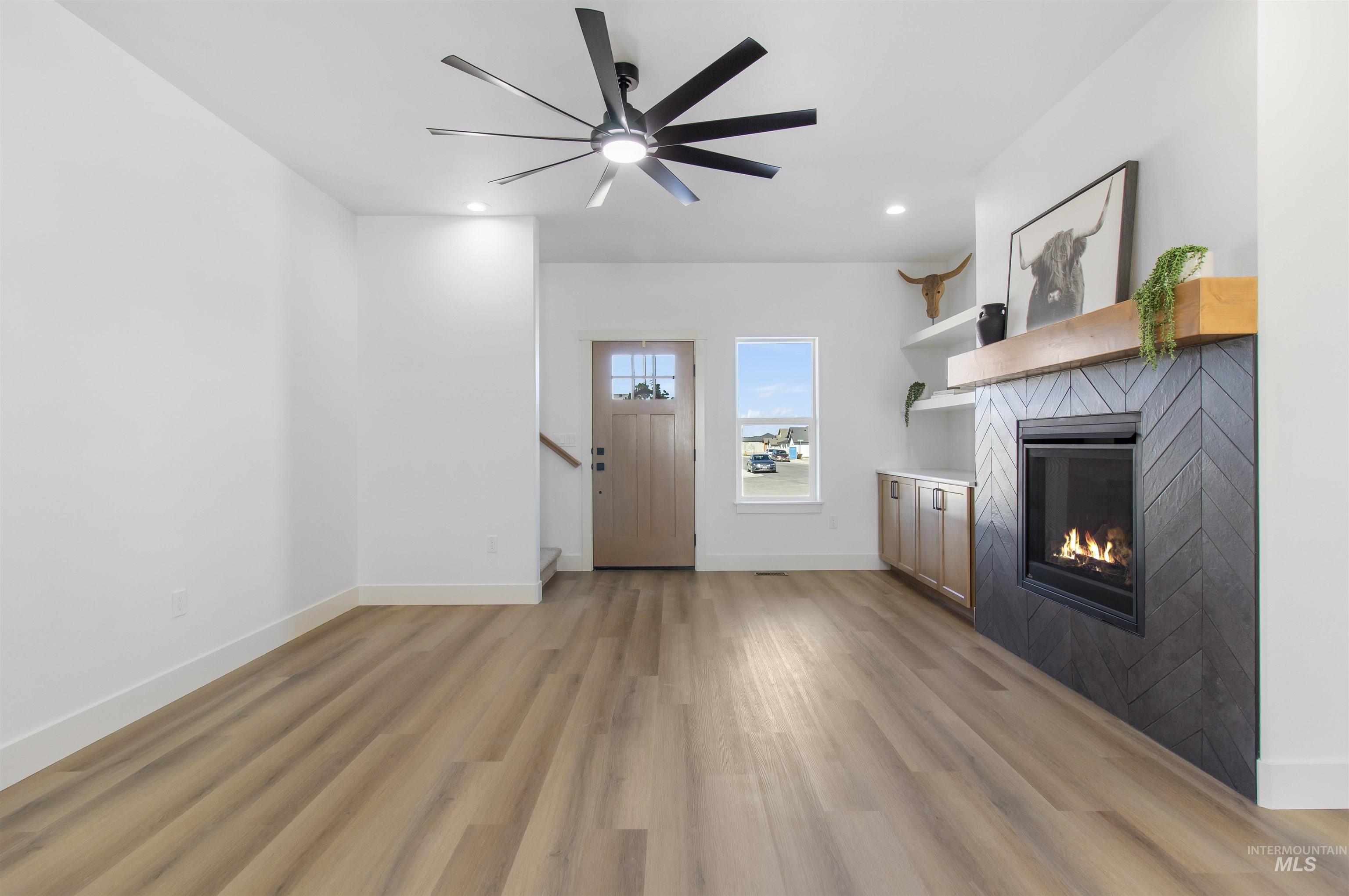 514 Full Moon Way Twin Falls, ID 83301 - Photo 7 of 49 Unfurnished living room with a tile fireplace, ceiling fan, light wood-style floors, and recessed lighting