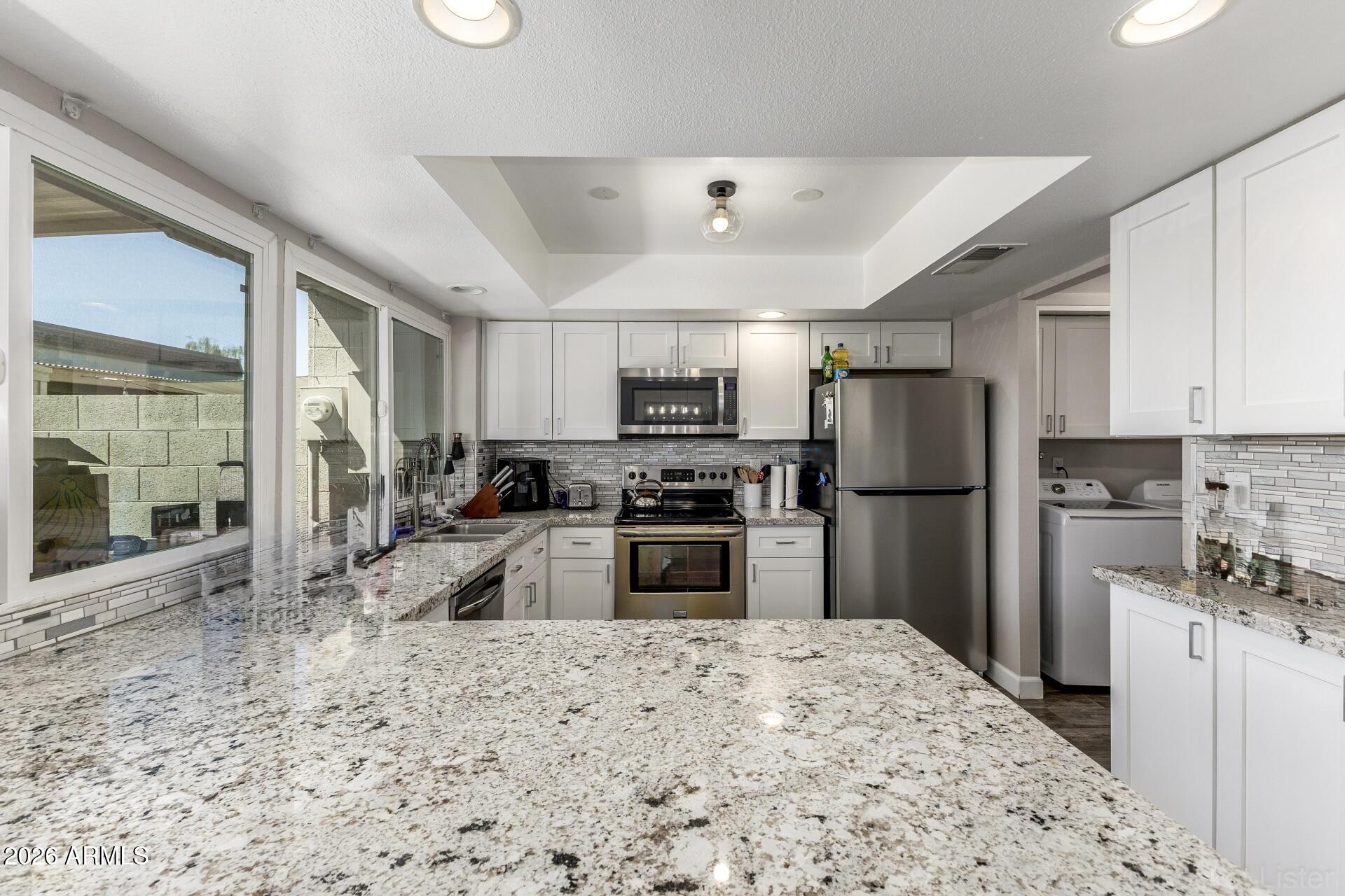 4923 North Granite Reef Road Scottsdale, AZ 85251 - Photo 8 of 28 a kitchen with a refrigerator a stove top oven a sink and dishwasher