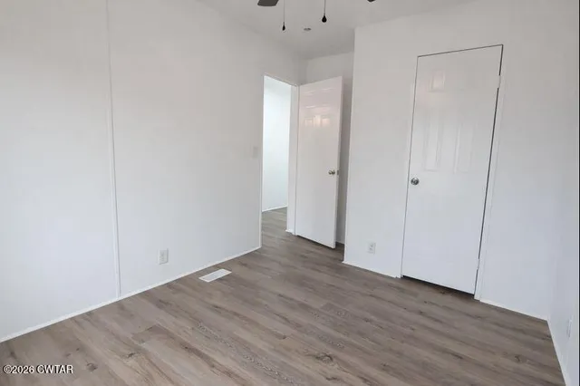 a view of an empty room with wooden floor