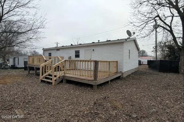 a view of a house with a yard and deck