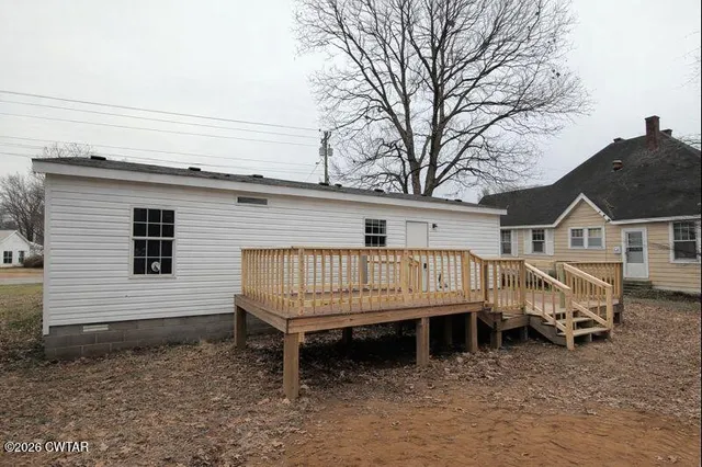 a view of house with a roof deck and furniture