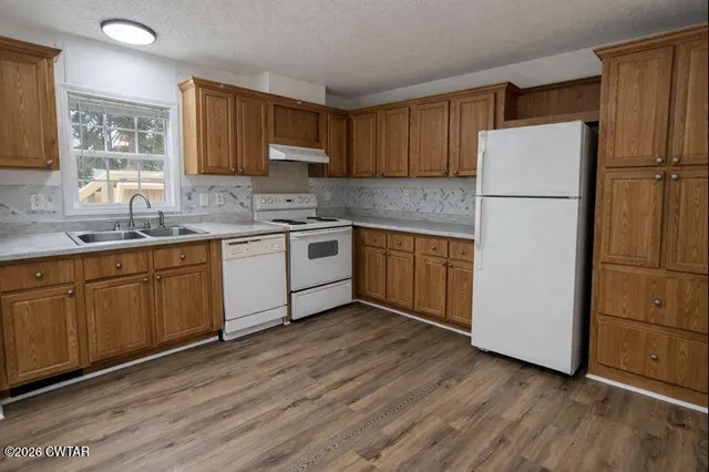 a kitchen with wooden cabinets and white appliances