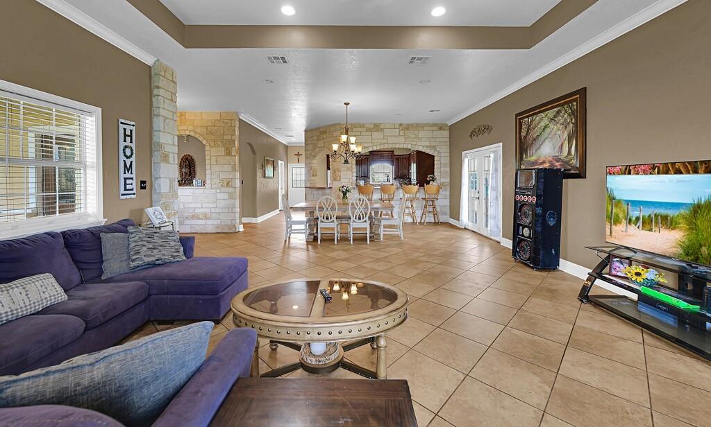 355 Highway 236 Moody, TX 76557 - Photo 16 of 36 Living room with a chandelier, light tile patterned floors, ornamental molding, baseboards, and recessed lighting