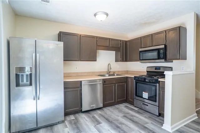 a kitchen with stainless steel appliances granite countertop a refrigerator stove and microwave