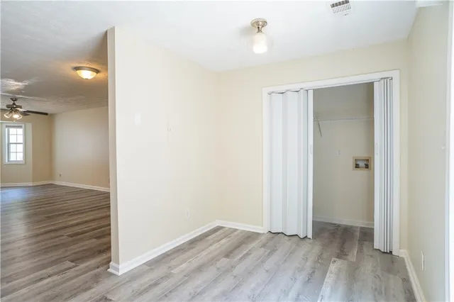 an empty room with wooden floor and windows